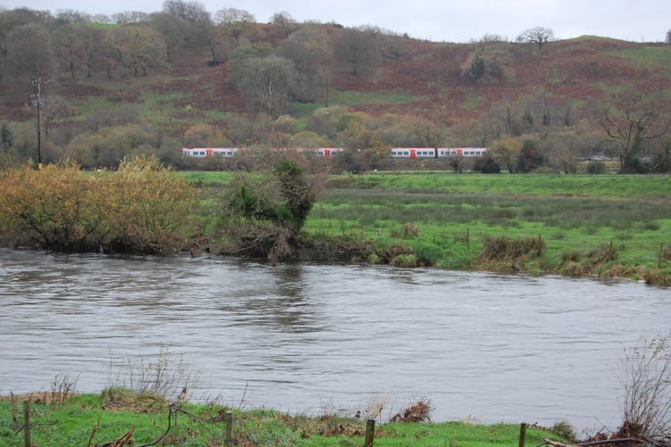 The new trains were being tested alongside the bursting banks of the river Dyfi as Storm Claudia's rains continued to make their mark across Wales. Photo: Cambrian News
