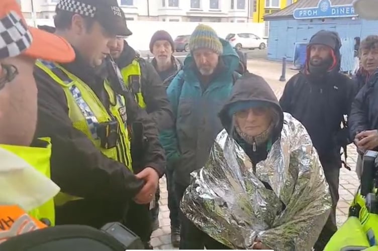 A vicar was one of the first to be arrested - this photo shows the scene before she is escorted to a police van.