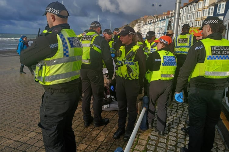 Police around a protestor on the floor at Aberystwyth Promenade during the Palestine Action protest. 