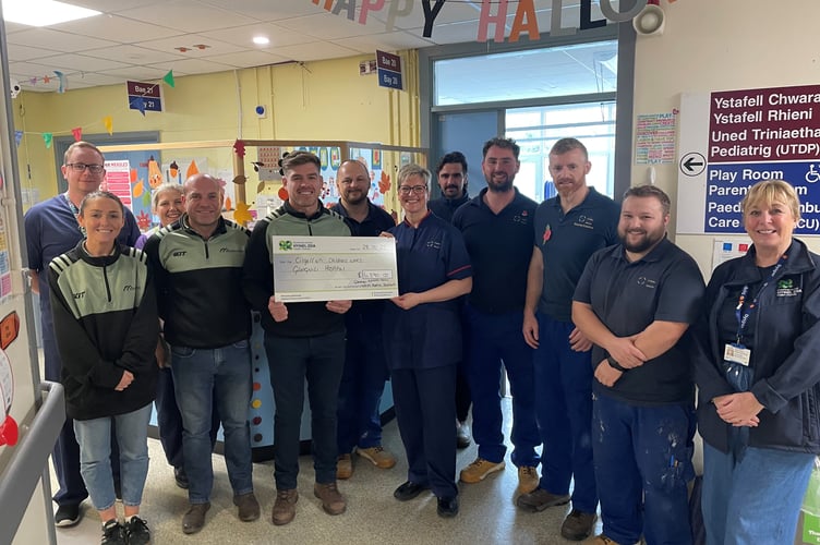 Representatives from Wales Roofing Solutions and the Estates Team at Glangwili present a cheque to Bethan Osmundsen, Senior Nurse Manager Acute Paediatrics, and team at Cilgerran Ward Glangwili Hospital