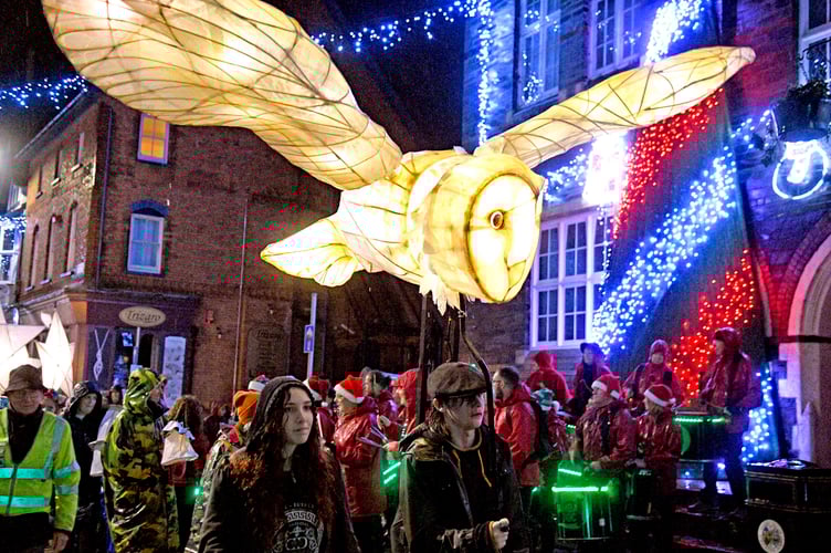 An owl lantern swoops low past the Guildhall
