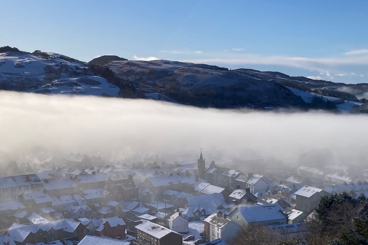 Machynlleth captured with a layer of mist over the snow.