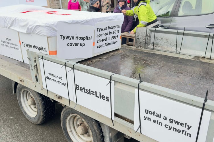 Tywyn hospital campaigners drove a trailer with an empty bed and placards through the town in protest at withdrawn services
