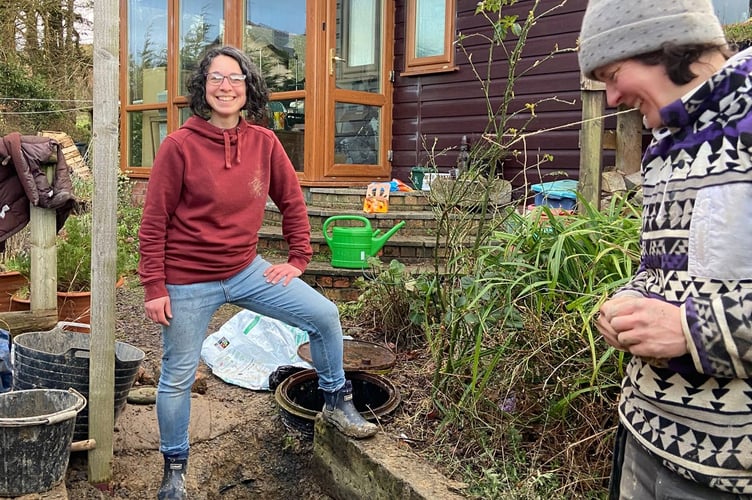Jane Baker standing over the newly dug hole.