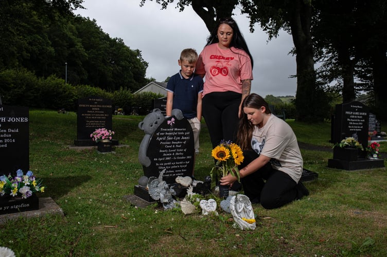 Hazel Louise Jones with her daughter Ameila-Louise Roxanne Davies and son Ethan-Daniel Richard Davies at April's grave in Machynlleth cemetery. July 21 2025. Five-year-old April Jones vanished while playing on her bike just yards from her home in the quiet Welsh town of Machynlleth. What followed was one of the biggest child search operations the UK has ever seen - thousands of volunteers, sniffer dogs, helicopters and a nation holding its breath.