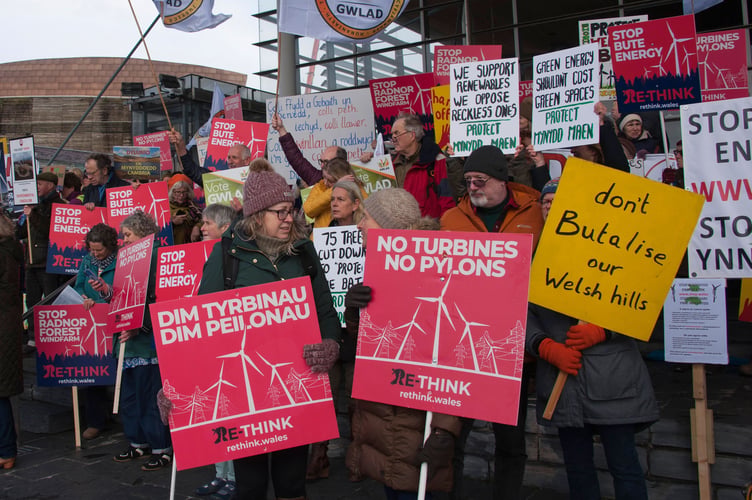 11/02/2026. Cardiff, UK. Many hundred opponents of plans by energy giants: Bute, Green GEN Cwmru and others, to build industrial scale wind farms throughout rural Wales, gather outside the Senedd for a mass protest organised by Llanwrtyd Wells Pylon Community Action Group, supported by Re-think.Wales and scheduled on the day of climate change, environment & infrastructure committee meeting.Proposals for colossal wind factories comprise hundreds of gigantic turbines up to 230 metres highâalmost 2 Â½ X height of Big Benâplus vast network of pylons.Protesters are not anti 'green' energy and say these turbines are not green, are inefficient, and will cost taxpayers billions of pounds from 'Wasted-Wind.' Also that this project is a modern day gold rush motivated by greed, causing huge disruption turning beautiful Welsh landscapes, vitally important for tourism, into eyesores. Scientific studies show huge turbines cause harm to health from infrasound.
