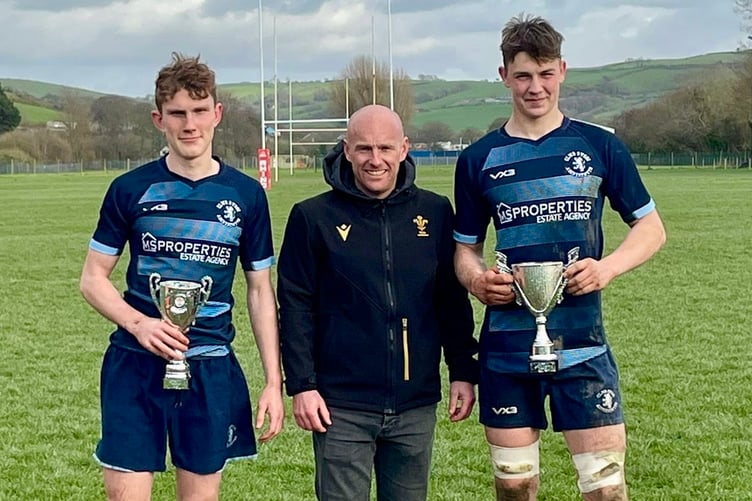 WRU rep Aled Walters presents captain Henri Michell and vice Toby Wilcockson the league trophies