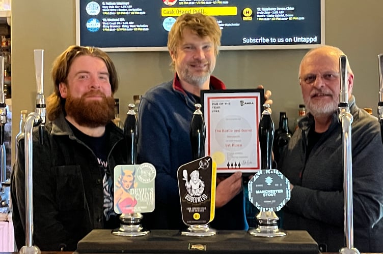 John Gale (right) presents the Bae Ceredigion CAMRA pub of the year award to Zac Marsden (centre) and Paddy Dixon (left) in the Bottle & Barrel