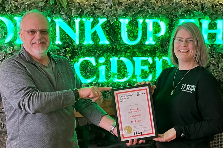 John Gale presents the Bae Ceredigion CAMRA cider pub of the year award to Ffion Roberts in Tŷ Seidr