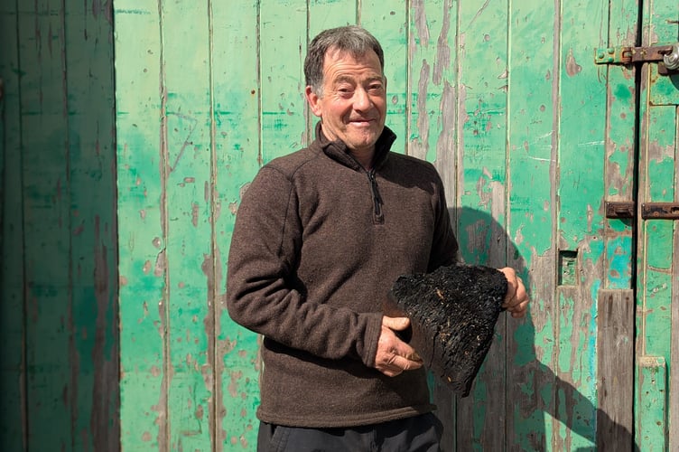 Gareth Roberts, holding the 'culprit' piece of wood which sent flames up his chimney. Photo: Cambrian News