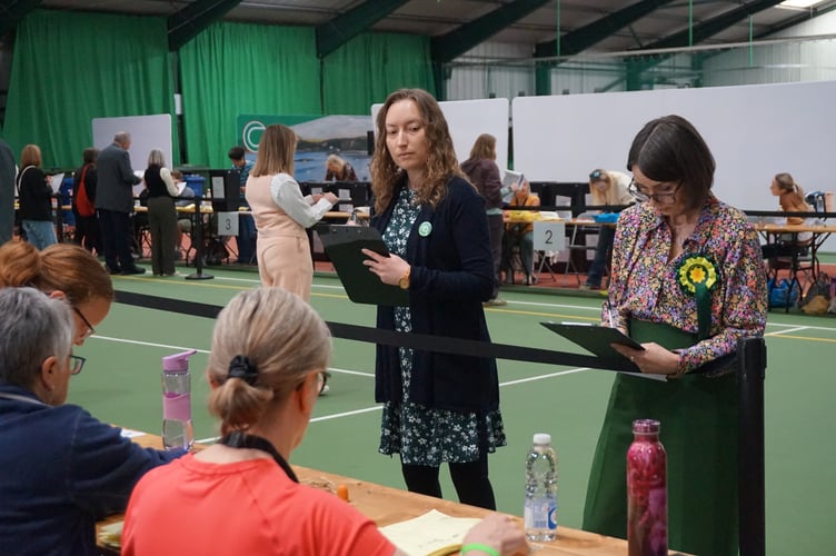 Counters from different political parties tallying the votes as they come in.