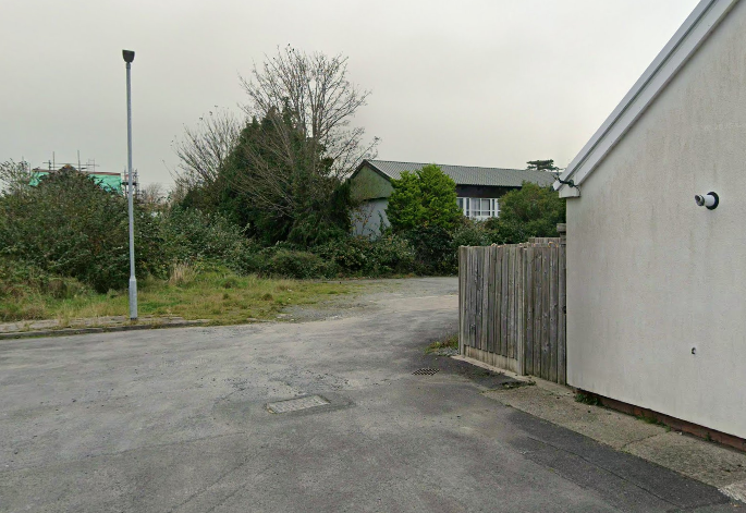 The site of the former Canolfan Meugan stretches behind homes on Rhos Y Dre