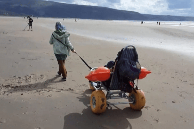 Angela Powers pulling her daughter Charlotte along the beach. Photo: Angela Powers
