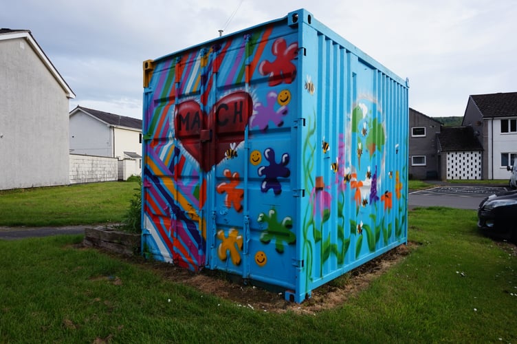 The PlayPod in Bryn y Gog, which stores toys and activities for young residents. The yellow grass shows where the herbicide has killed off the plants. Photo: Cambrian News