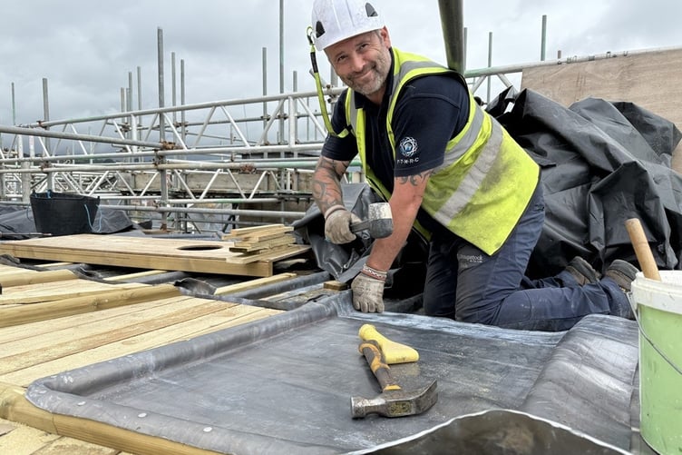 Dale Canning, one of the lead working team, fitting a newly bossed panel on the flat roof of South Seddon.