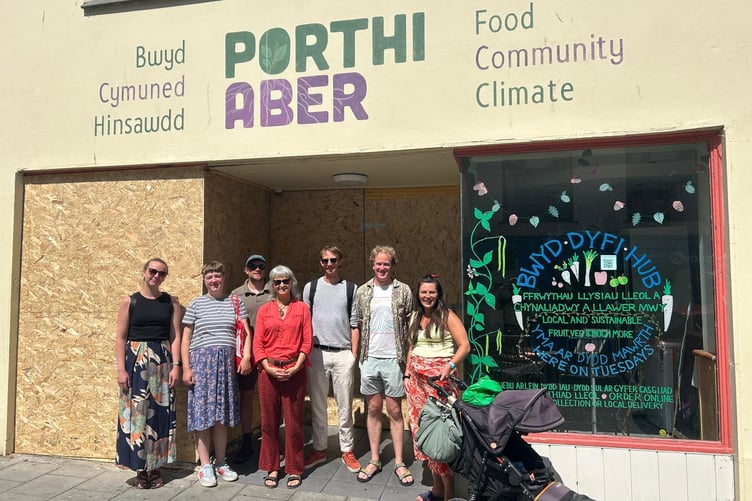 Staff and volunteers outside the repaired shop front.