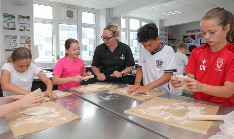 Harlech Foodservice's summer holiday pizza-making session at Ysgol y Moelwyn at Blaenau Ffestiniog.
Harlech Foodservice's Ursula Scurrah-Price preparing a pizza bases with Beca Orr, Mali Humphreys, Cory Lynch and Ceri Williams