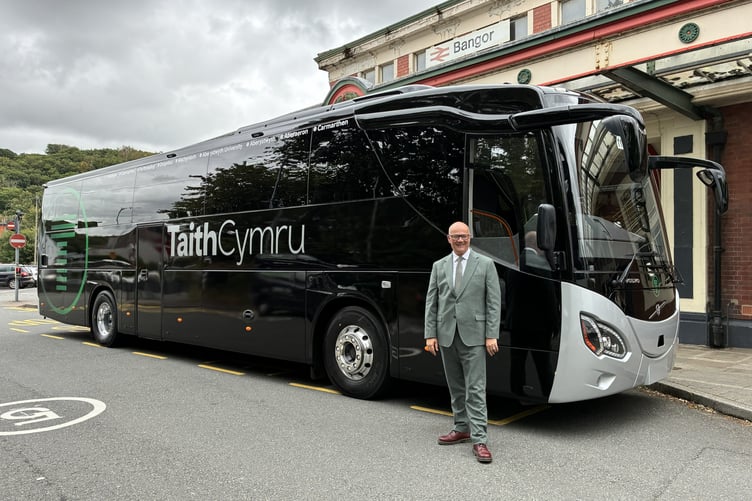 Deputy Minister for Transport Mark Hooper with a new TaithCymru coach in Bangor