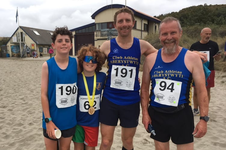 Owain Schiavone with his sons Moi and Now and Dave Humphreys at the Poppit Sands 5K race