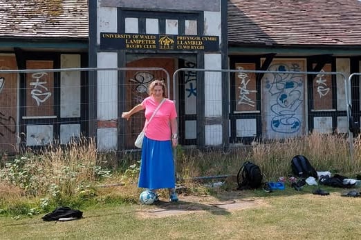 Lampeter Society member Helena Rachel Thomas, pictured in front of the dilapidated former university cricket pavilion