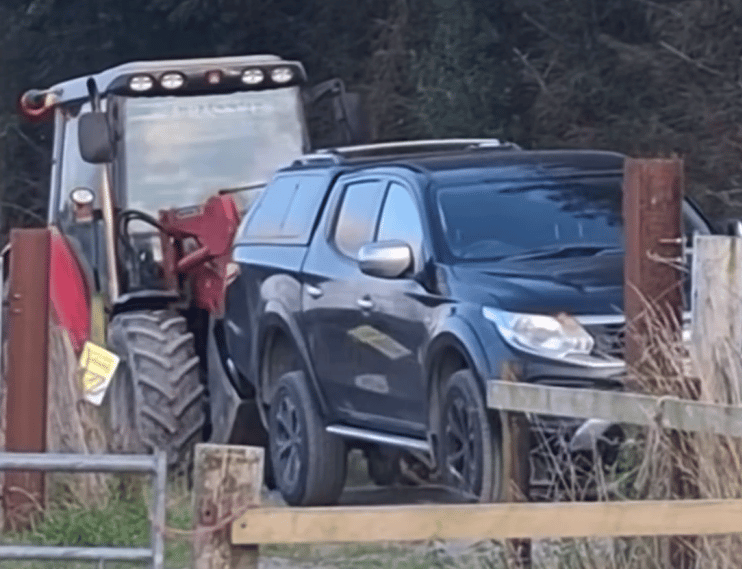 The tractor moving the pickup truck