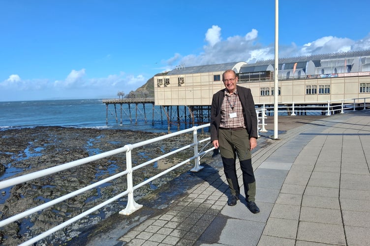 Mike Davies o flaen y pier yn Aberystwyth
